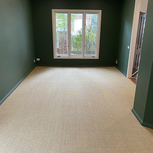 Serene room with green walls and a large window, featuring elegantly woven natural sisal flooring in Autumn Slate.