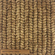 Thick, tan abaca fibers intricately braided, showcasing rich texture and artisanal craftsmanship in sustainable natural flooring.