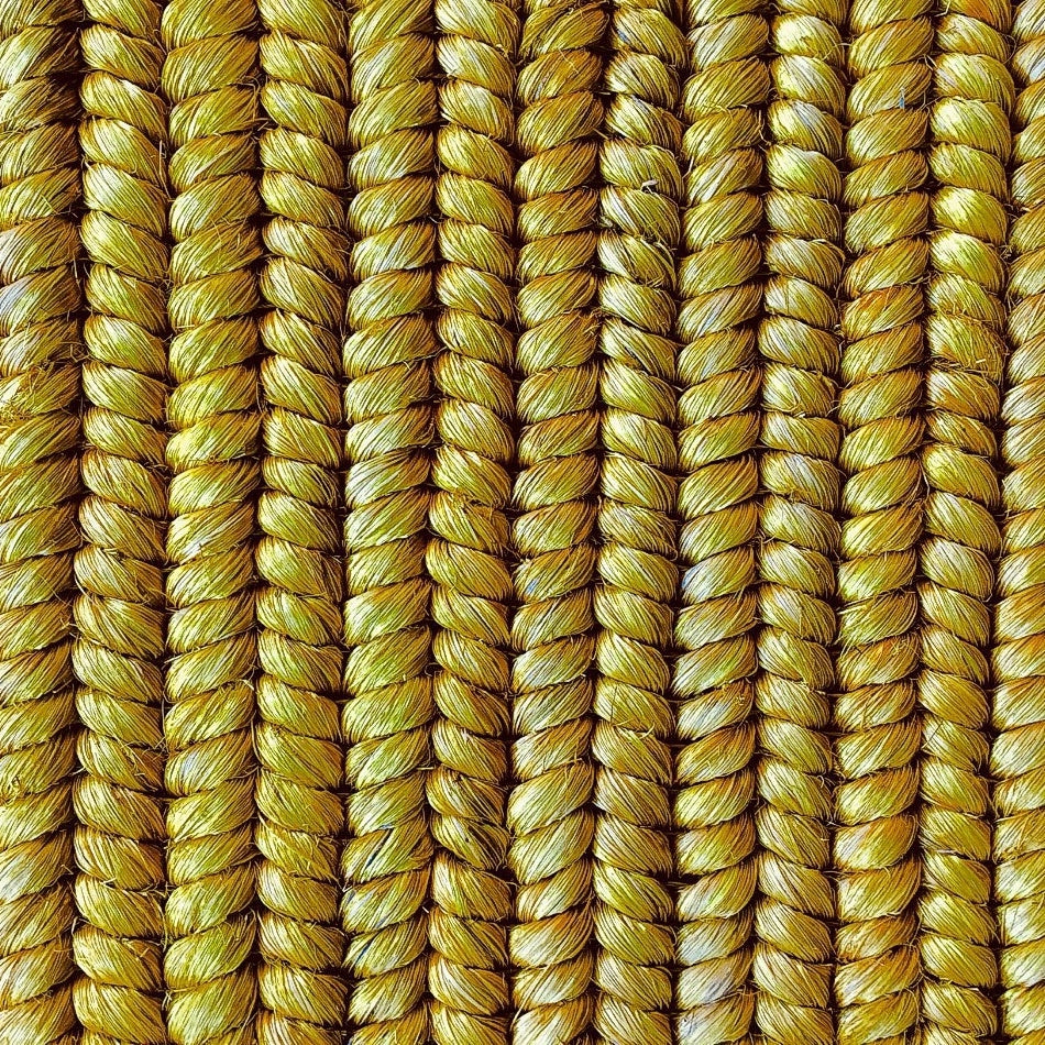 Vertical strands of richly textured, golden yellow natural fibre rope showcase artisanal weaving and refined craftsmanship.
