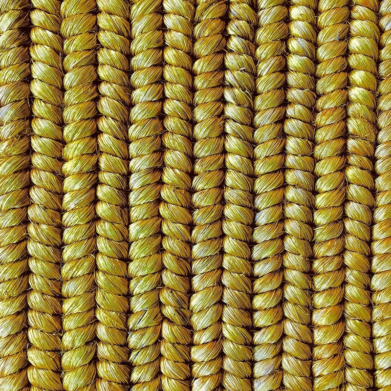 Vertical strands of richly textured, golden yellow natural fibre rope showcase artisanal weaving and refined craftsmanship.