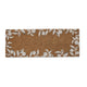 Rectangular natural fibre doormat, warm brown tone with refined white leafy branch edging; styled on a modern entryway floor.