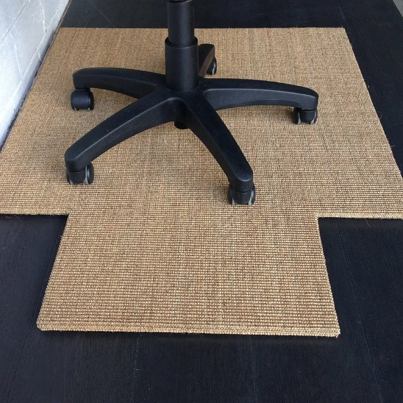 Tan sisal chair pad with precise cutout, resting by a white wall, showcases refined texture and natural craftsmanship.