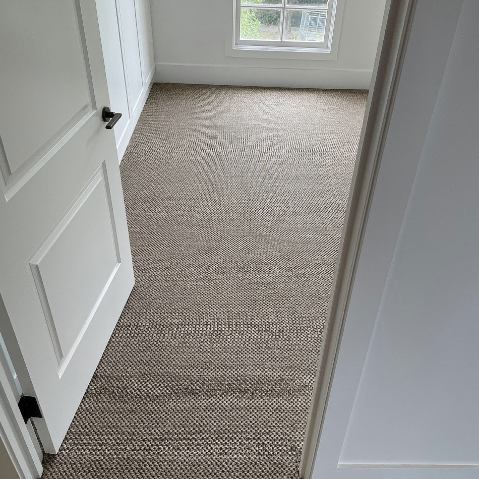 Sunlit minimalist room with white walls, open door, and finely textured Granite Sisal flooring creating a refined natural ambiance.