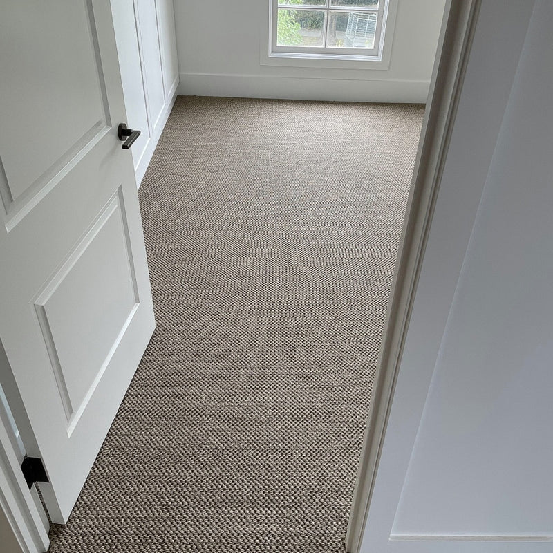 Sunlit minimalist room with white walls, open door, and finely textured Granite Sisal flooring creating a refined natural ambiance.