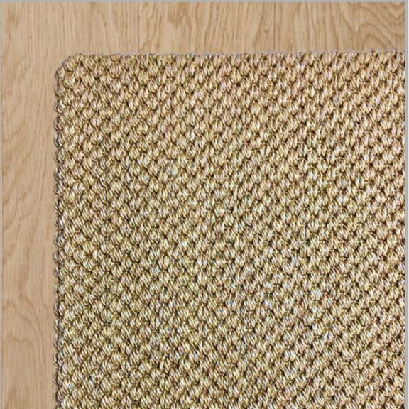 Tuck Under Border wool and jute rug, natural fibers woven with precision, sits on pale timber flooring in an elegantly styled space.