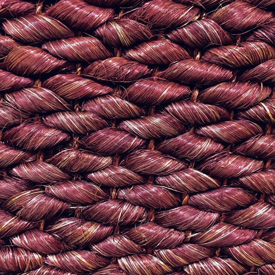 Tightly braided maroon and brown natural fibres in a refined, textured weave, showcasing rich, artisanal quality and durability.