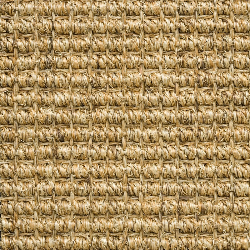Detailed view of thick, interwoven natural sisal fibers highlighting rich texture and refined craftsmanship in sustainable flooring.