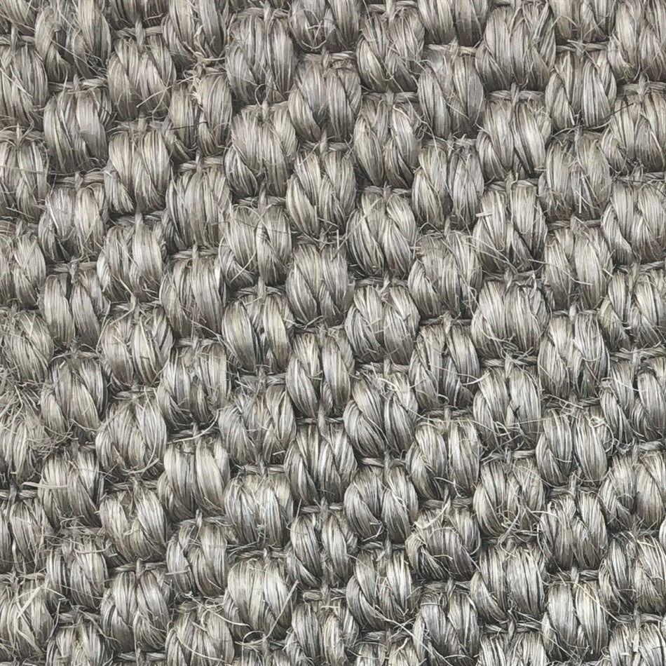Thick, looped grey sisal fibers with a rustic granite texture, highlighting premium craftsmanship and lasting quality.