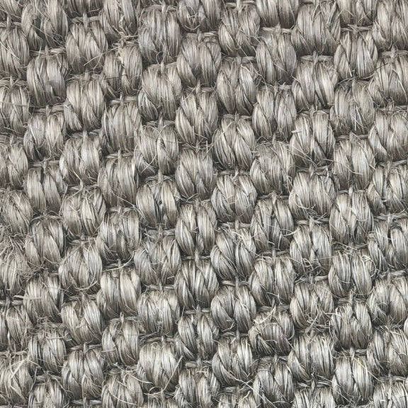 Thick, looped grey sisal fibers with a rustic granite texture, highlighting premium craftsmanship and lasting quality.