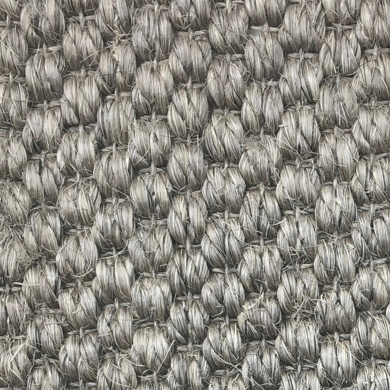 Thick, looped grey sisal fibers with a rustic granite texture, highlighting premium craftsmanship and lasting quality.