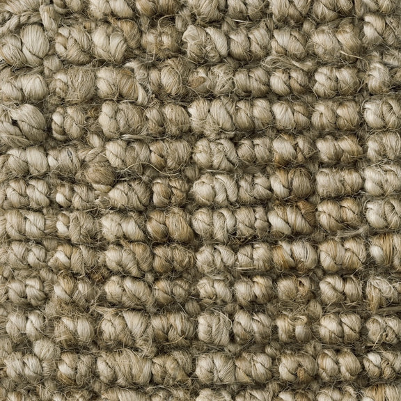 Detail of finely woven light brown jute carpet, highlighting its natural texture and premium artisanal craftsmanship.