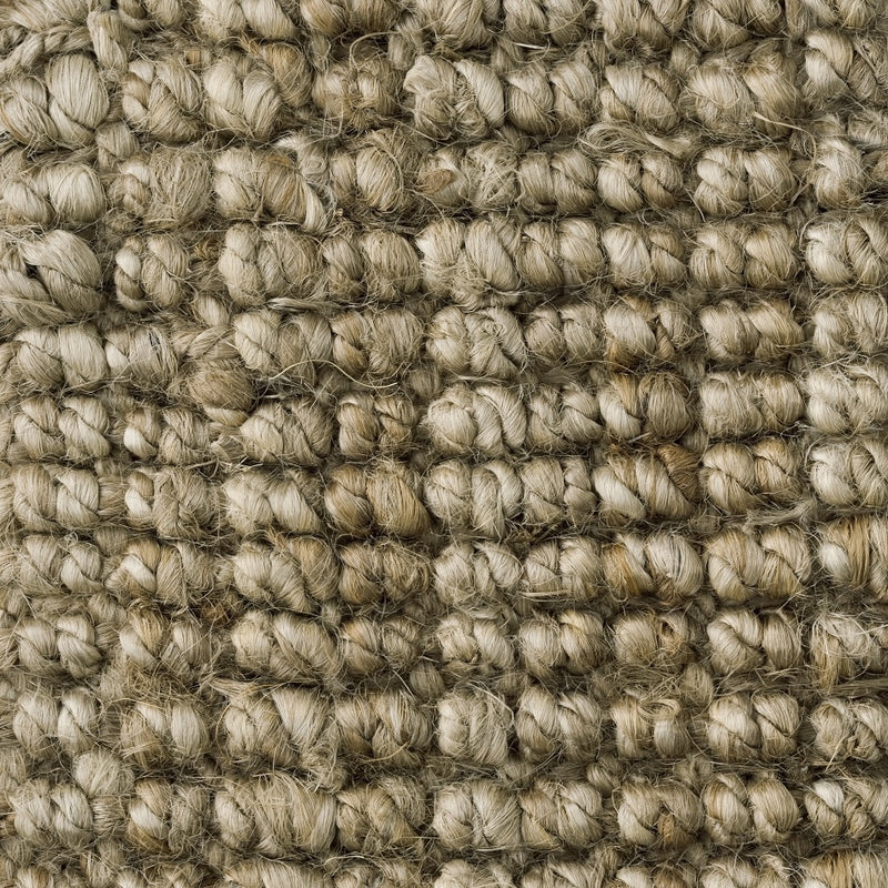 Detail of finely woven light brown jute carpet, highlighting its natural texture and premium artisanal craftsmanship.