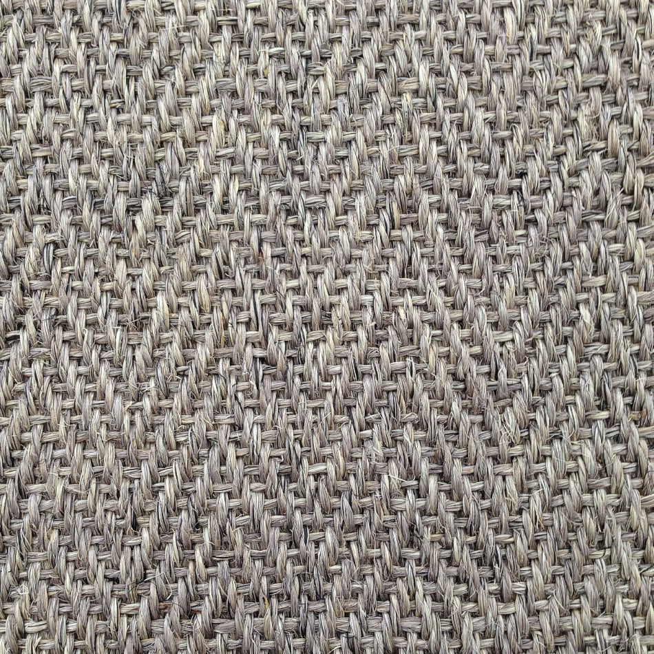 Detailed view of herringbone sisal carpet in soft beige and grey, highlighting refined texture and quality natural fibres.