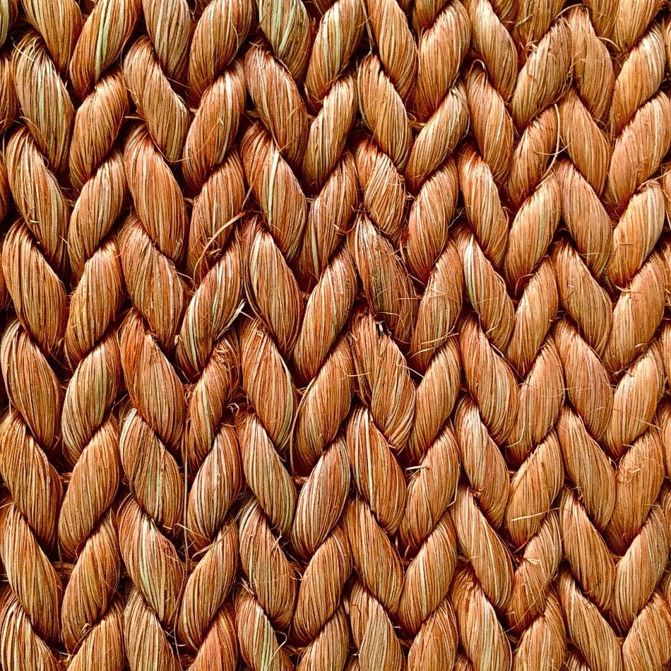Detailed view of finely woven brown abaca fibres in a herringbone pattern, showcasing artisanal texture and natural elegance.