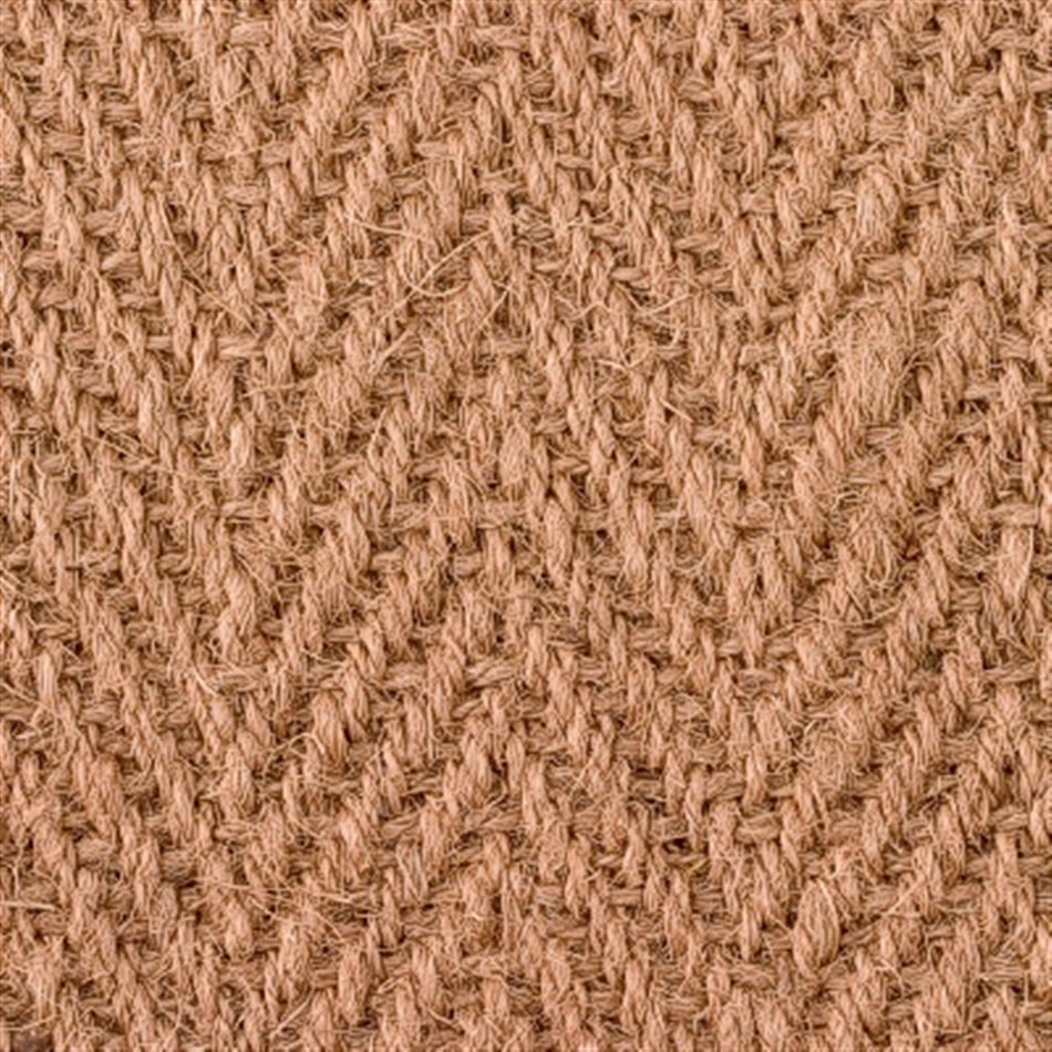 Detailed view of a herringbone coir rug, showcasing handwoven jute texture and warm natural brown fibres.