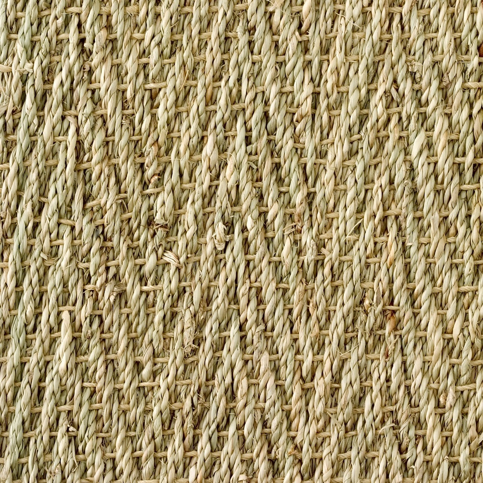 Detailed view of finely woven, textured beige seagrass in a distinct herringbone pattern, highlighting natural fibre craftsmanship.