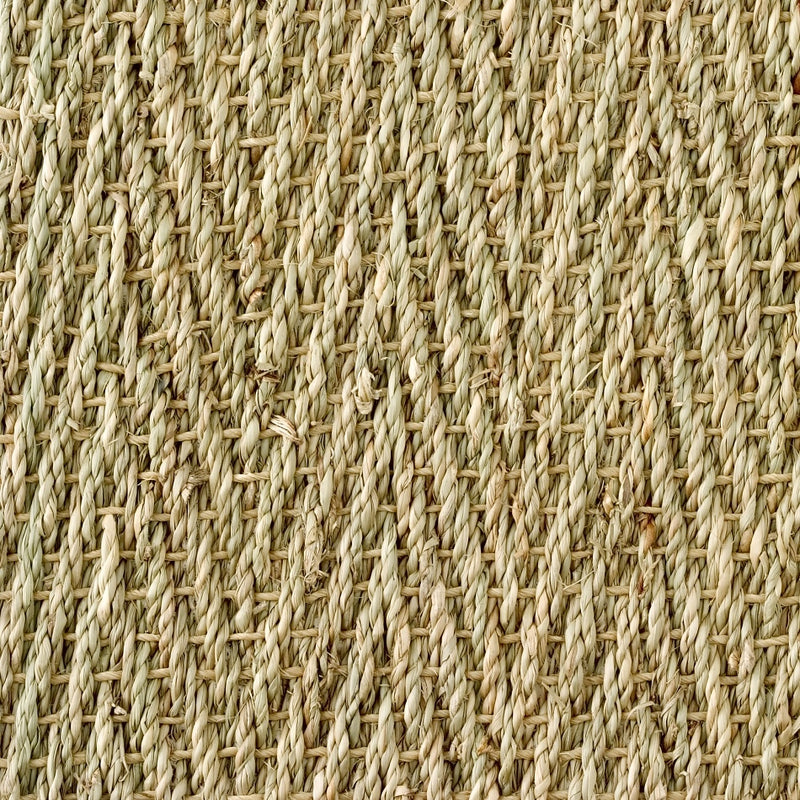 Detailed view of finely woven, textured beige seagrass in a distinct herringbone pattern, highlighting natural fibre craftsmanship.
