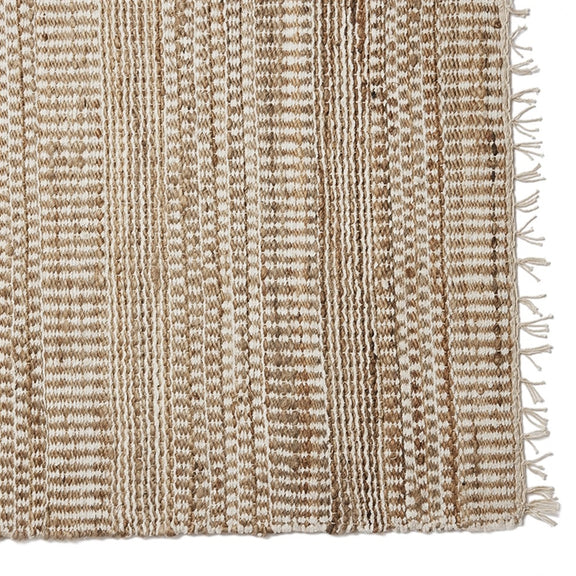A refined runner with soft beige and white stripes, tactile tassels, and a natural woven texture enhances an elegant home interior.