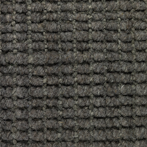 Detail of a Mineral Grey wool and jute rug, showcasing thick, textured grid weave and refined natural fibre craftsmanship.