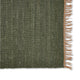 Moss green jute rug with a tan fringe edge, showcasing rich texture and refined craftsmanship on natural fibre flooring.
