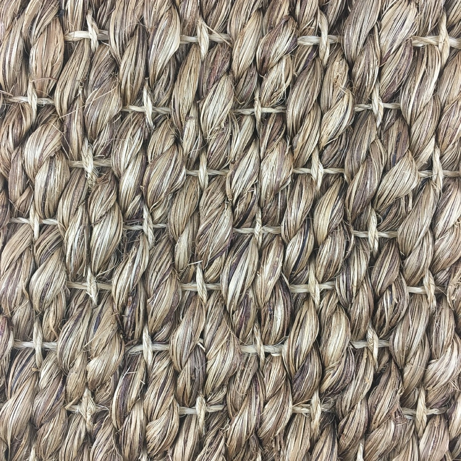 Thick, twisted natural abaca fibers woven in a refined crisscross pattern, showcasing artisanal craftsmanship and durability.