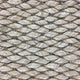 Thick beige natural fibre rope strands woven in an intricate, durable pattern, highlighting artisanal craftsmanship and quality.