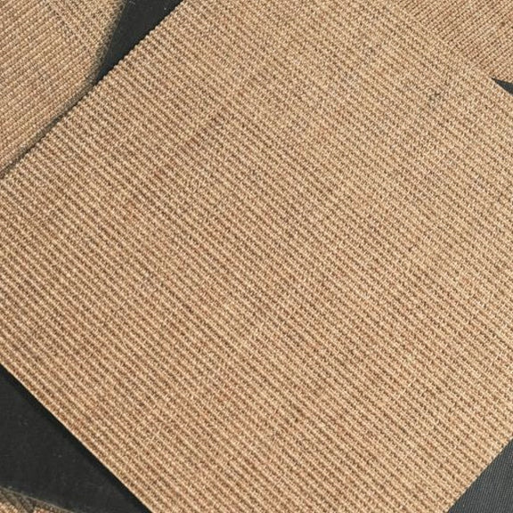 Detailed view of handwoven sisal tiles, displayed at an angle on a dark surface, highlighting natural texture and refined quality.