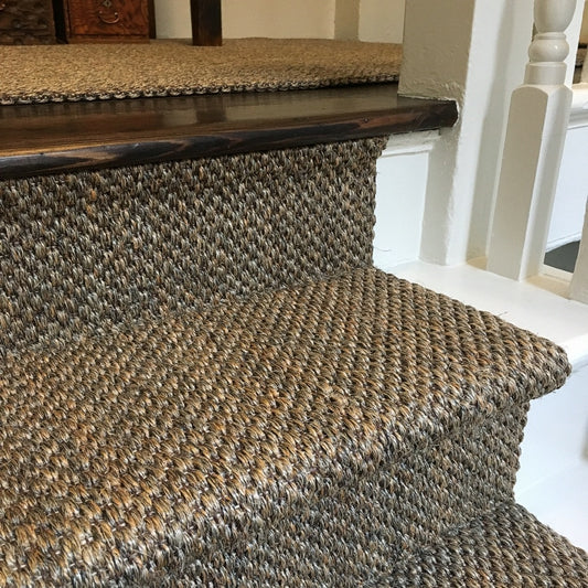 Elegant staircase featuring a Fine Rustic Slate Sisal runner and crisp white-painted wood trim in a refined, light-filled interior.