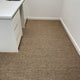 A bright, inviting corner with a white countertop and an elegant sisal rug, highlighting natural texture and refined design.