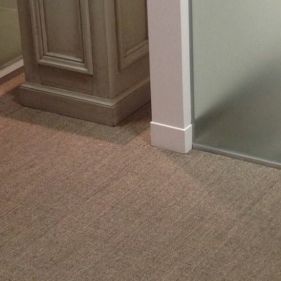 Elegant room corner with fine ribbed granite sisal flooring, frosted glass wall, and warm wood cabinetry.