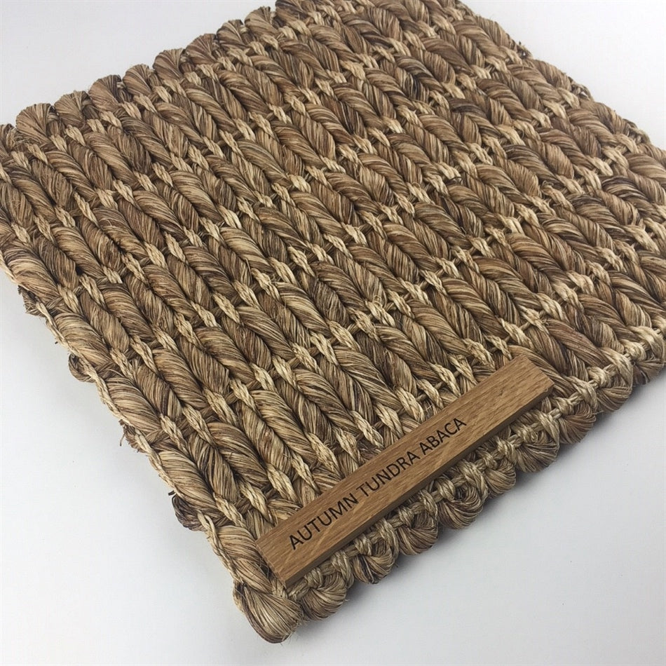 Thick, square-weave abaca rug in a natural tone, showcasing rich texture and sustainable craftsmanship on a contemporary floor.