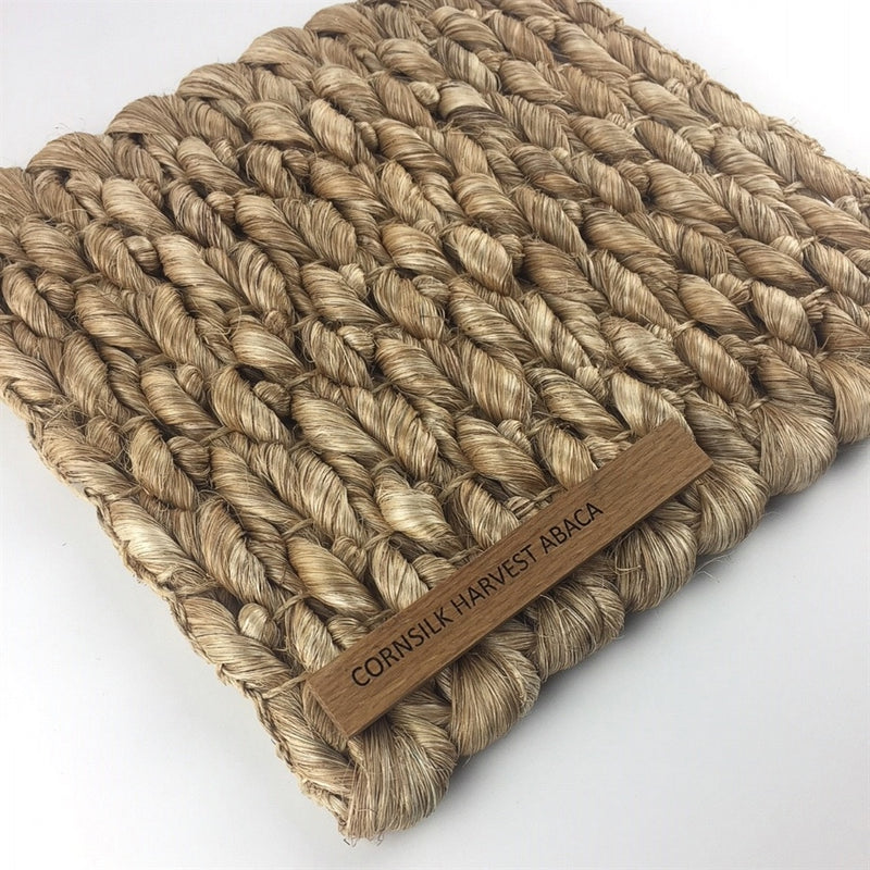 A thick, woven natural fibre mat in warm cornsilk tones, showcasing quality craftsmanship and sustainable elegance.