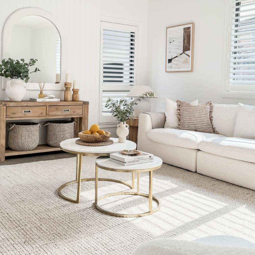 A bright living room with a white sofa, round tables, and premium natural fibre flooring enhancing the elegant, modern design.