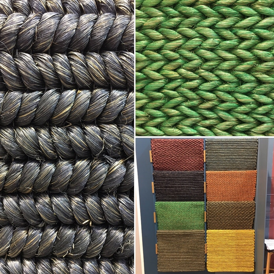 Thick woven ropes in deep black and rich green, paired with vibrant handcrafted rugs on a smooth surface, highlighting artisanal quality.